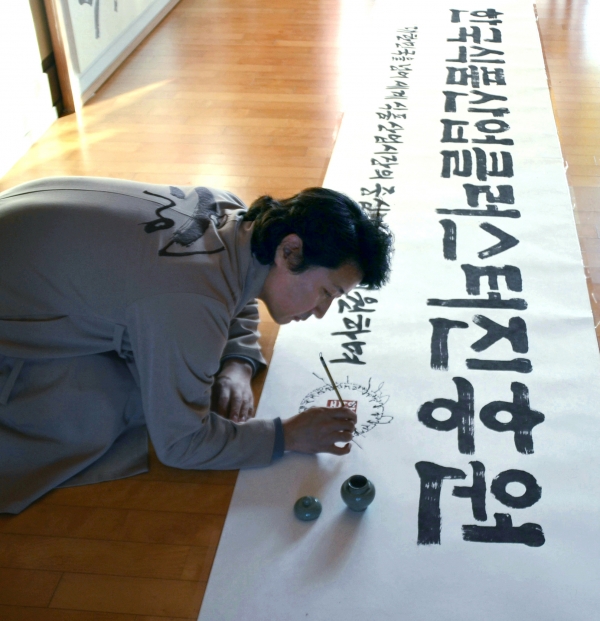 한한국 석좌교수가 한국식품산업클러스터진흥원 새 현판 휘호를 쓰고 있다.