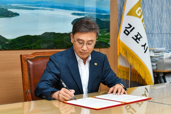 정하영 김포시장이 한강과 염하강 철책 철거사업 협약서에 서명하고 있다. ⓒ김포시 제공